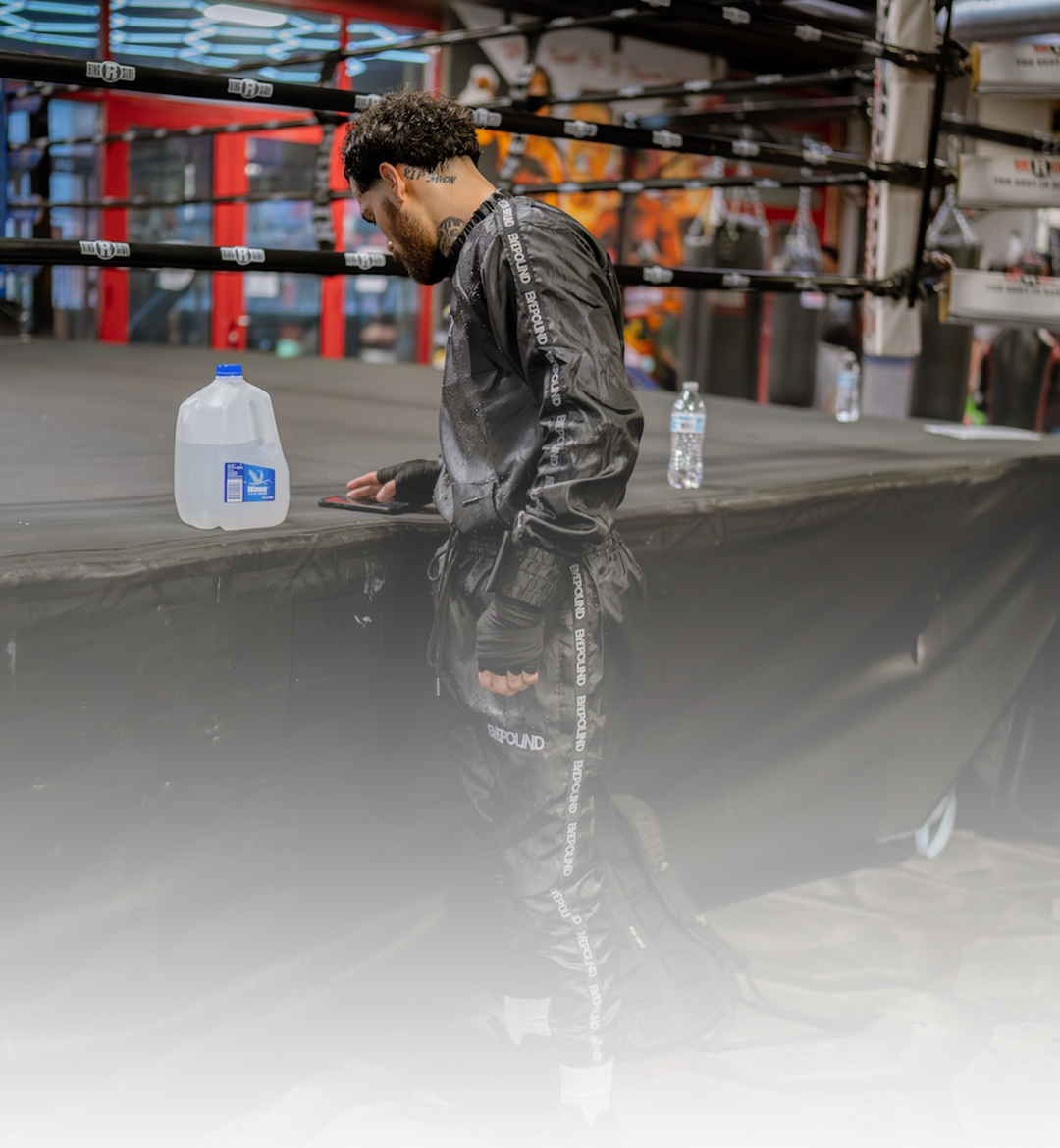 Byepound athlete in the signature taped tracksuit beside the ring