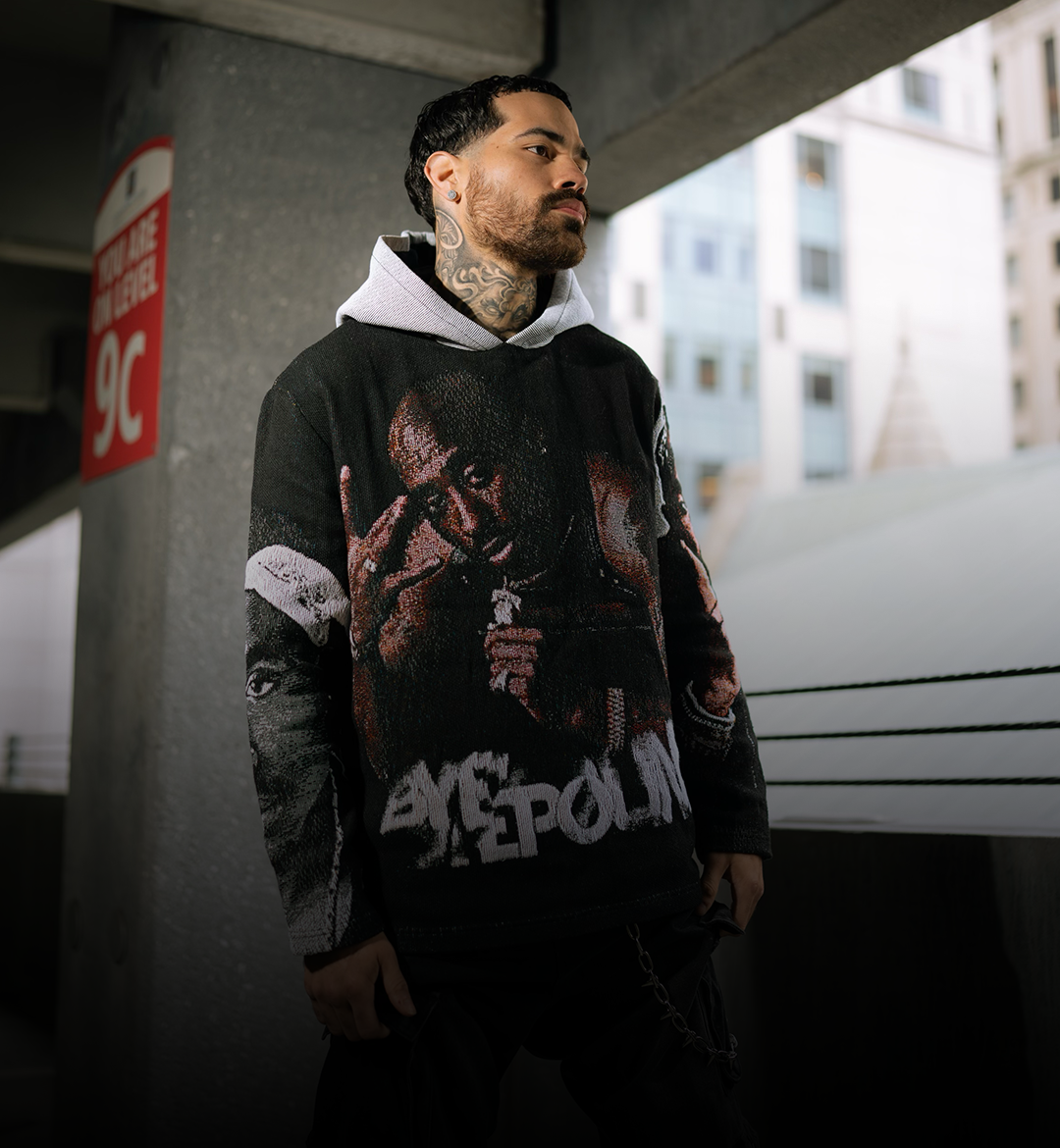 Byepound signature tapestry hoodie shot in an urban parking structure